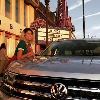 jessica hernandez leaning on VW vehicle in front of marquis with her name on it