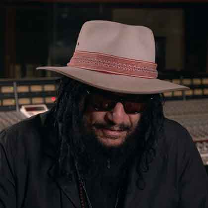Don Was sitting at mixing board in recording studio